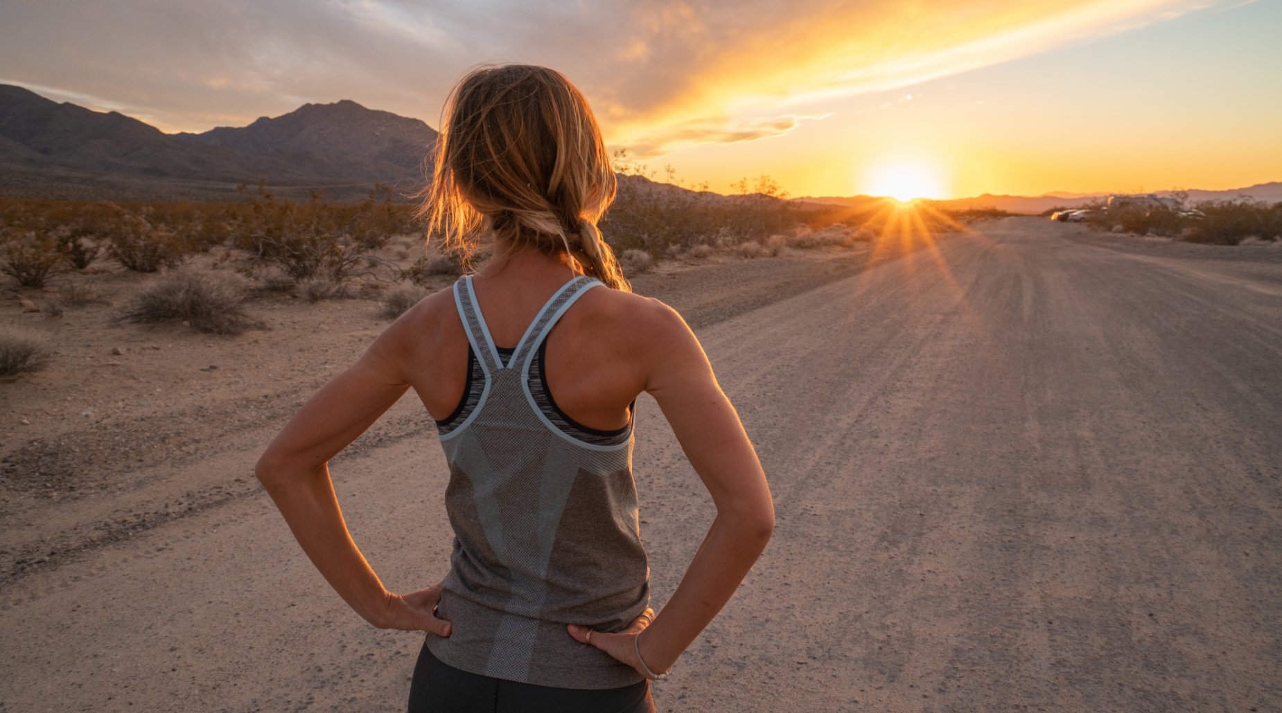 Female runner on dirt road at sundown