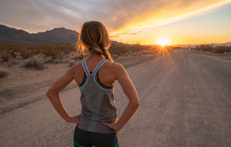 Female runner on dirt road at sundown